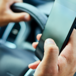 Closeup of person handling cell phone while driving a car